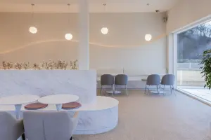 웨이브 간접조명이 돋보이는 미니멀 화이트 카페